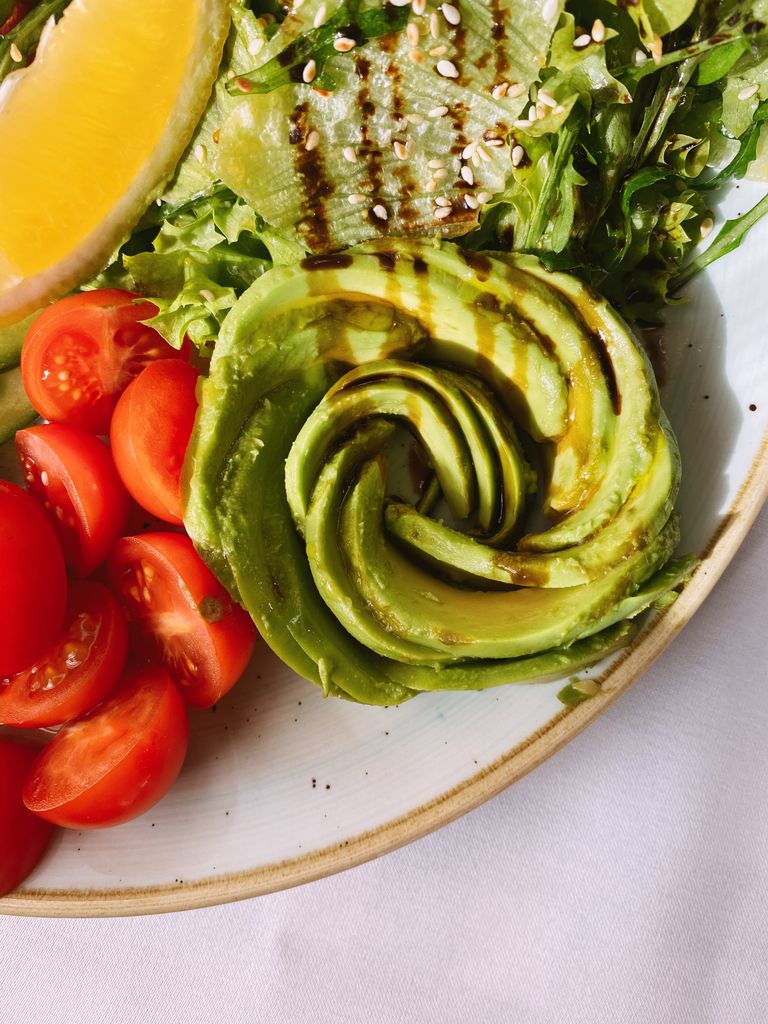 Close-up of a fresh avocado salad with cherry tomatoes and lemon, perfect for healthy eating.