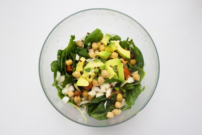 Fresh spinach salad featuring avocado and chickpeas, perfect for healthy eating.