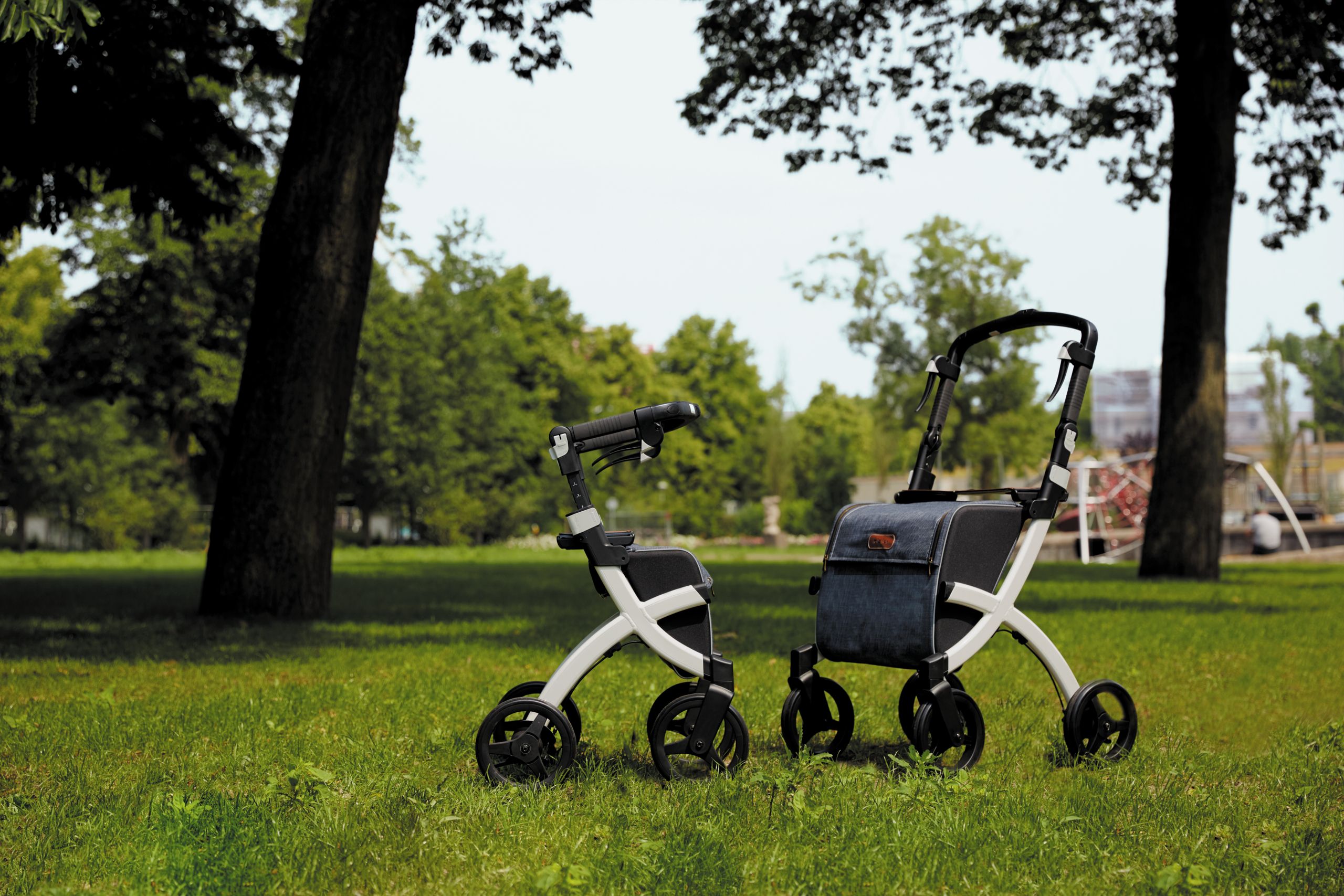 Two modern rollators on a grassy park in summer.