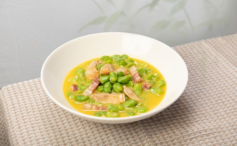 A bowl of savory fava bean and bacon stew, perfect for a comforting meal.