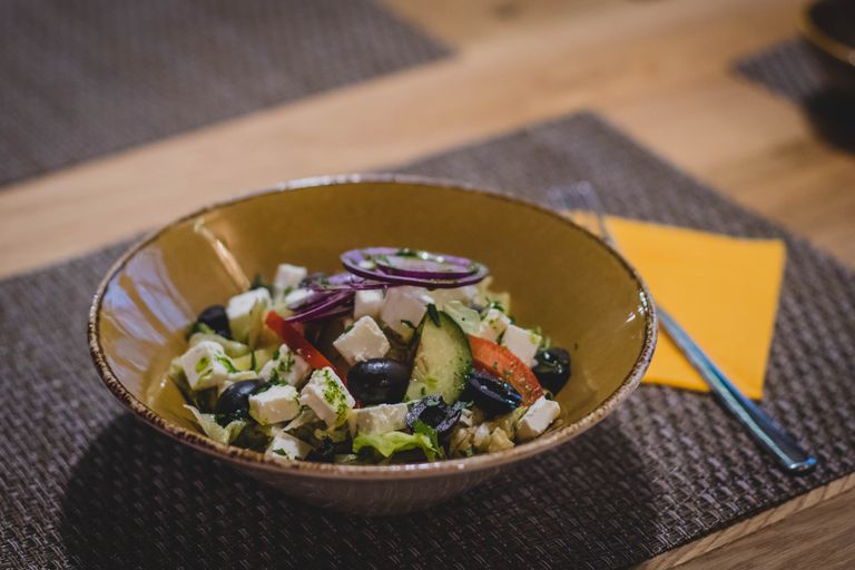A delicious Greek salad featuring feta cheese, olives, and fresh vegetables in a rustic bowl.