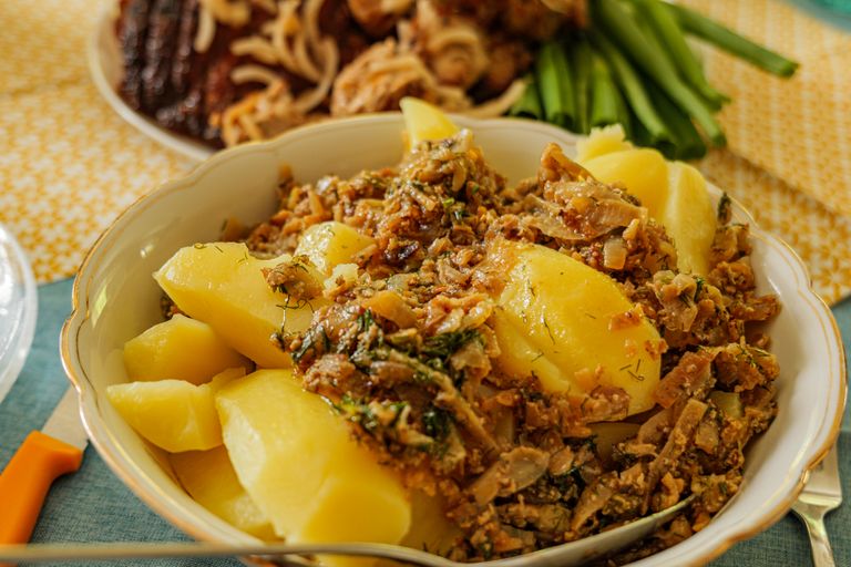 A delicious plate of German potatoes garnished with mixed herbs and spices, perfect for a hearty meal.
