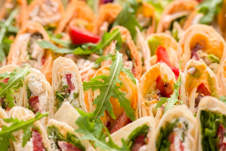 A vibrant assortment of tortilla wraps filled with fresh vegetables and greens.