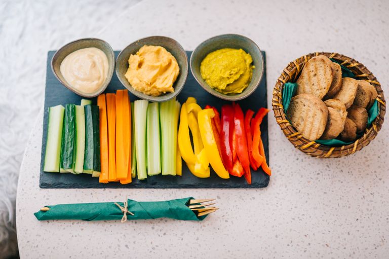 A vibrant vegetable platter with hummus and bread, ideal for healthy eating.