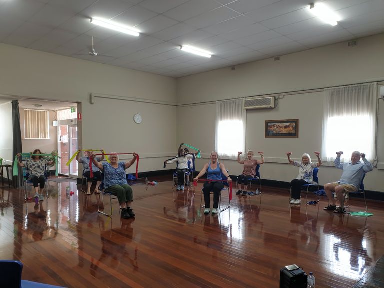 Active seniors engaging in a chair exercise class, promoting wellness and positive aging.