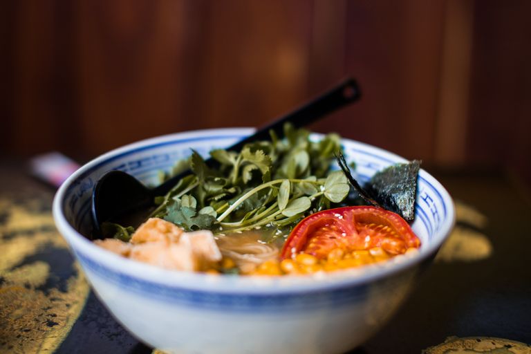 Close-up of a savory ramen bowl with fresh vegetables and vibrant ingredients, perfect for food enthusiasts.