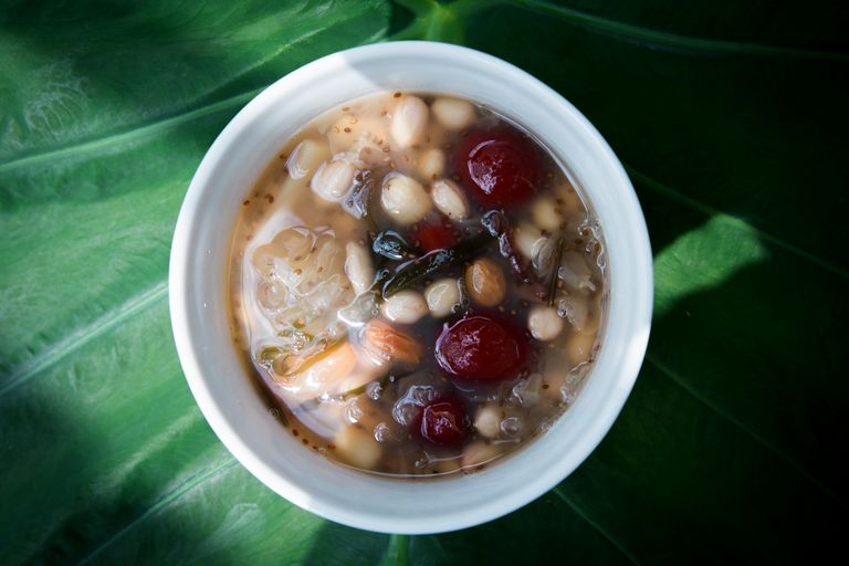 Close-up of a traditional Vietnamese sweet dessert with beans and nuts in a bowl.