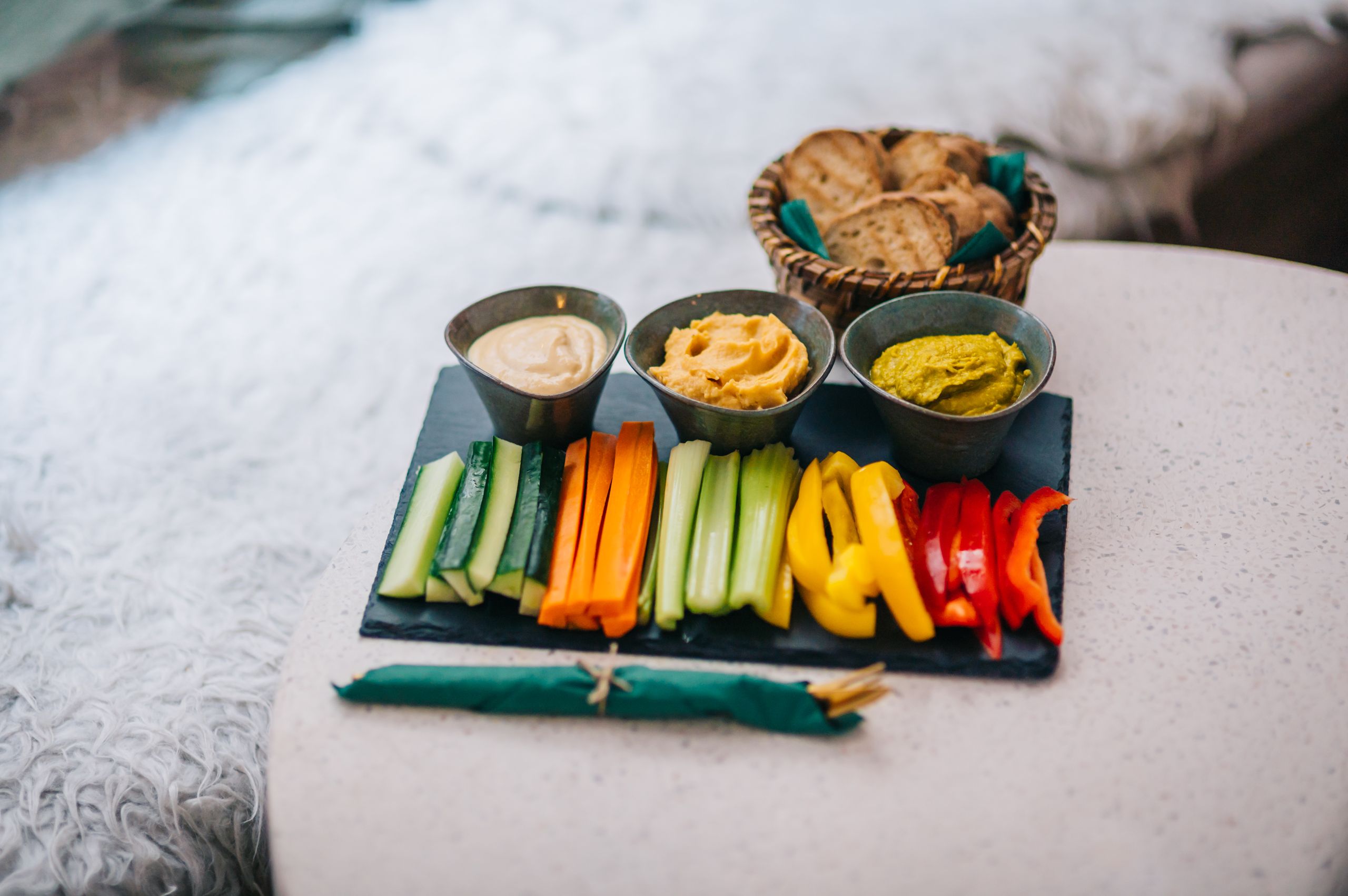Colorful vegetable platter with dips and bread, perfect for healthy snacking.