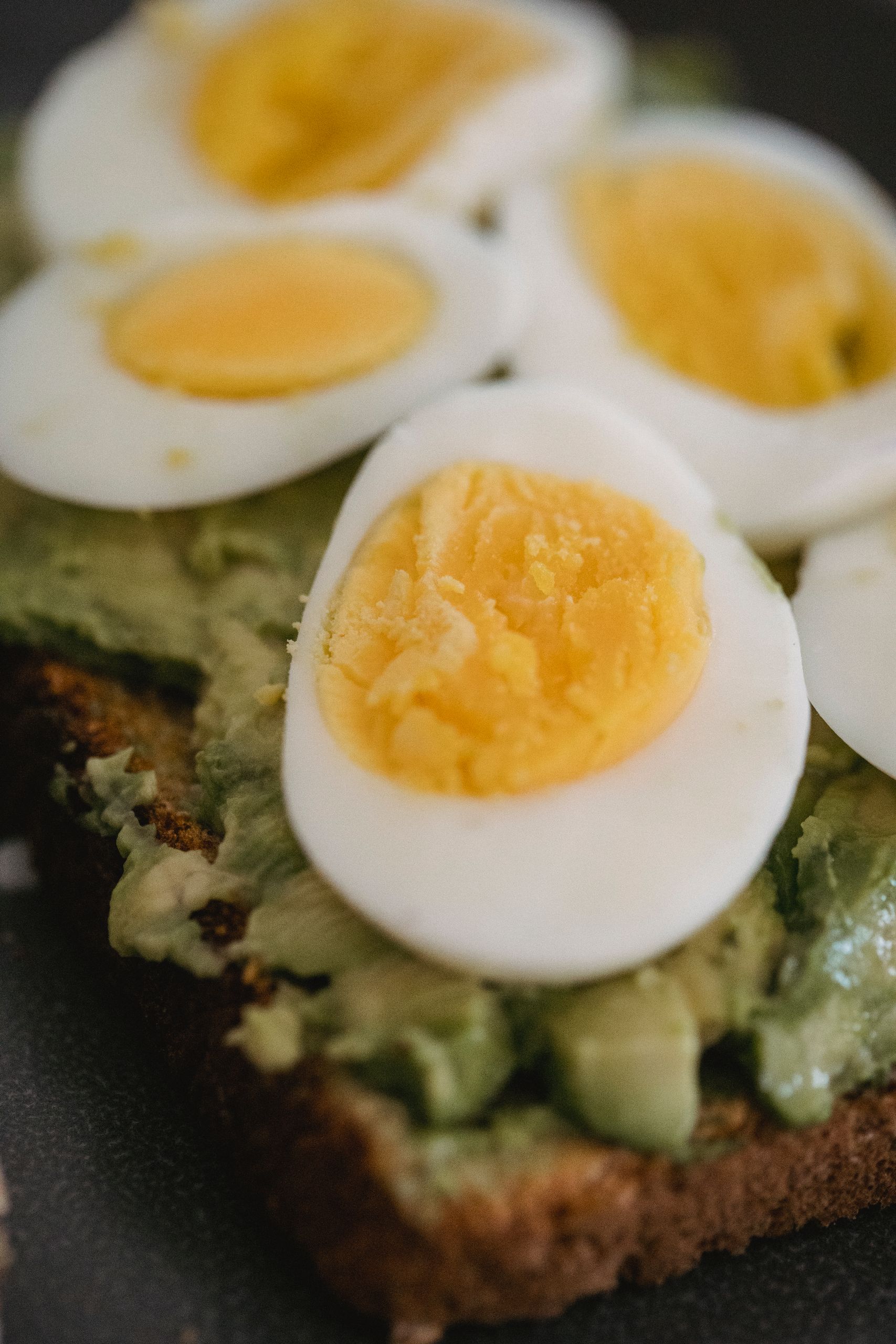 Delicious avocado toast topped with perfectly sliced boiled eggs, ideal for a healthy breakfast.