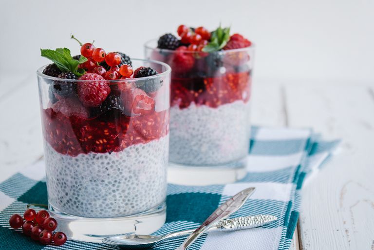 Delicious chia pudding topped with fresh berries and mint on a checkered napkin.
