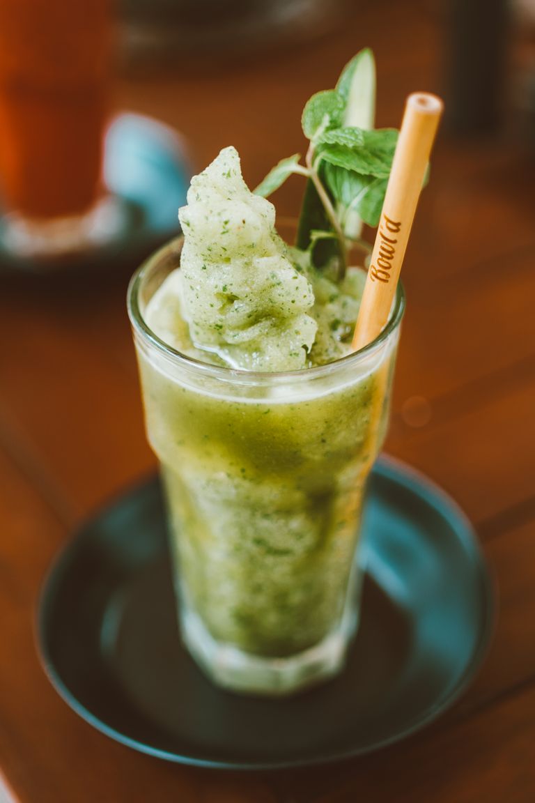 Delicious green smoothie in a glass with mint garnish, perfect for a refreshing beverage.