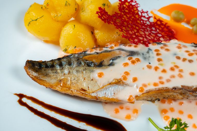 Delicious grilled fish serving with dill potatoes and a creamy sauce, perfect for a hearty meal.
