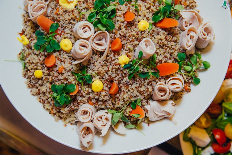 Delicious quinoa salad with fresh vegetables and rolled meat, elegantly plated.