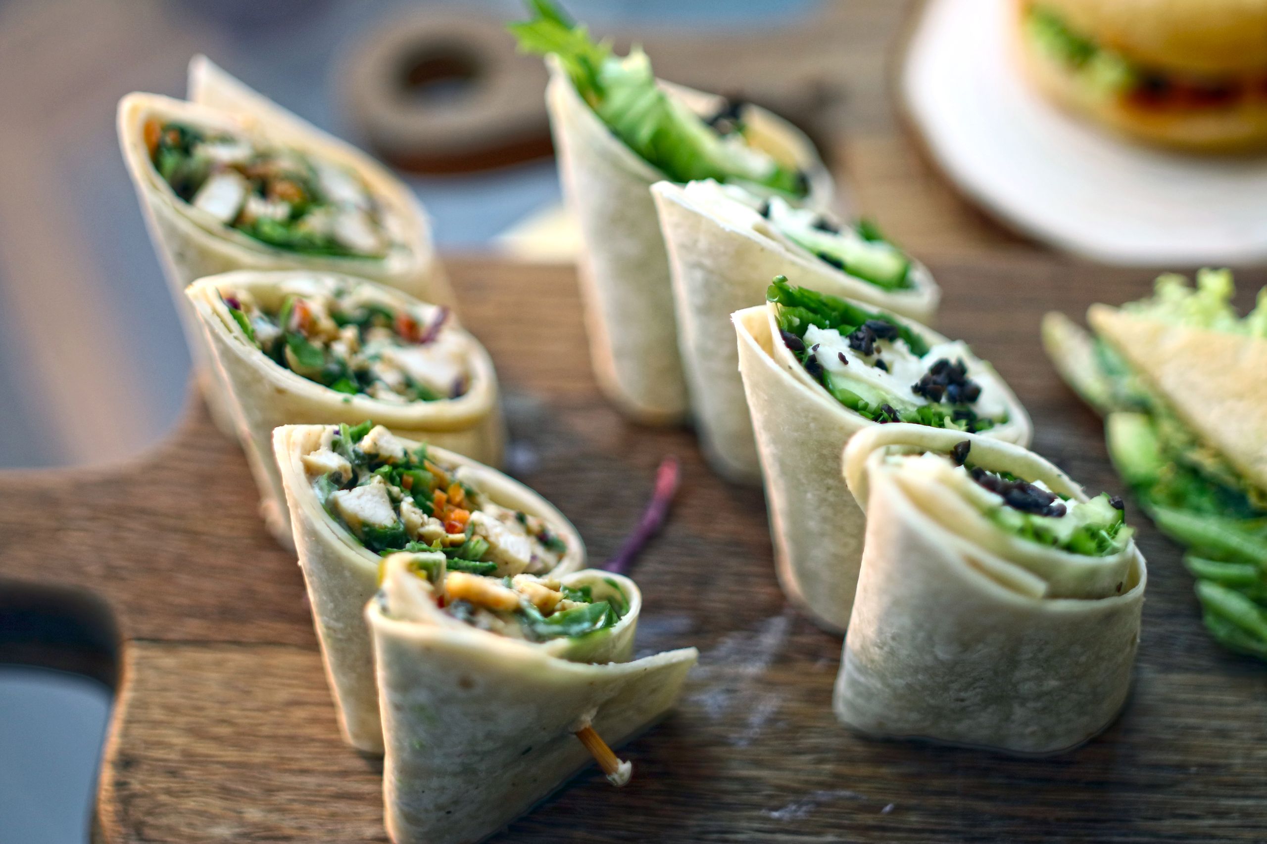 Delicious vegetarian wraps with greens on a wooden board for a fresh snack.