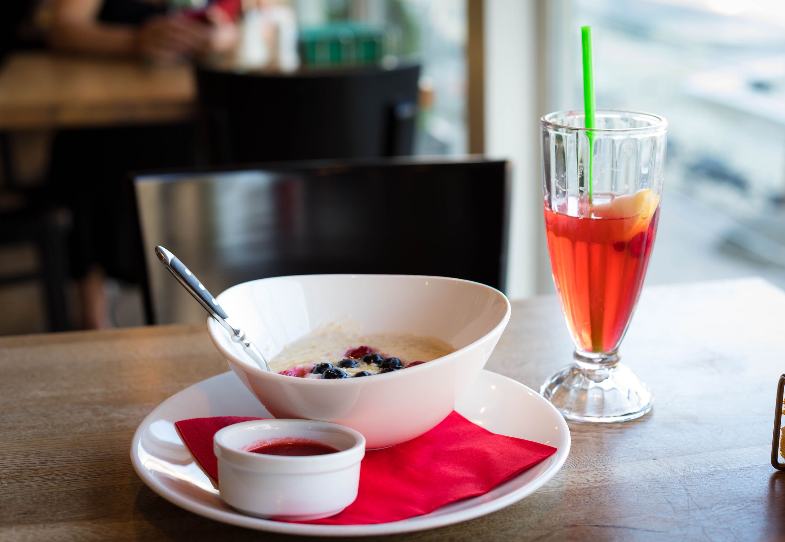 Delightful breakfast setting with a bowl of porridge and colorful fruit juice in a café.