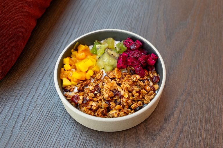 Healthy and colorful breakfast bowl with fresh fruits and granola on a wooden table.