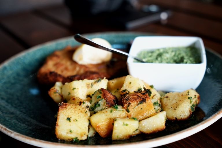 Tantalizing plate of herb roasted potatoes paired with chimichurri sauce, perfect for food lovers.
