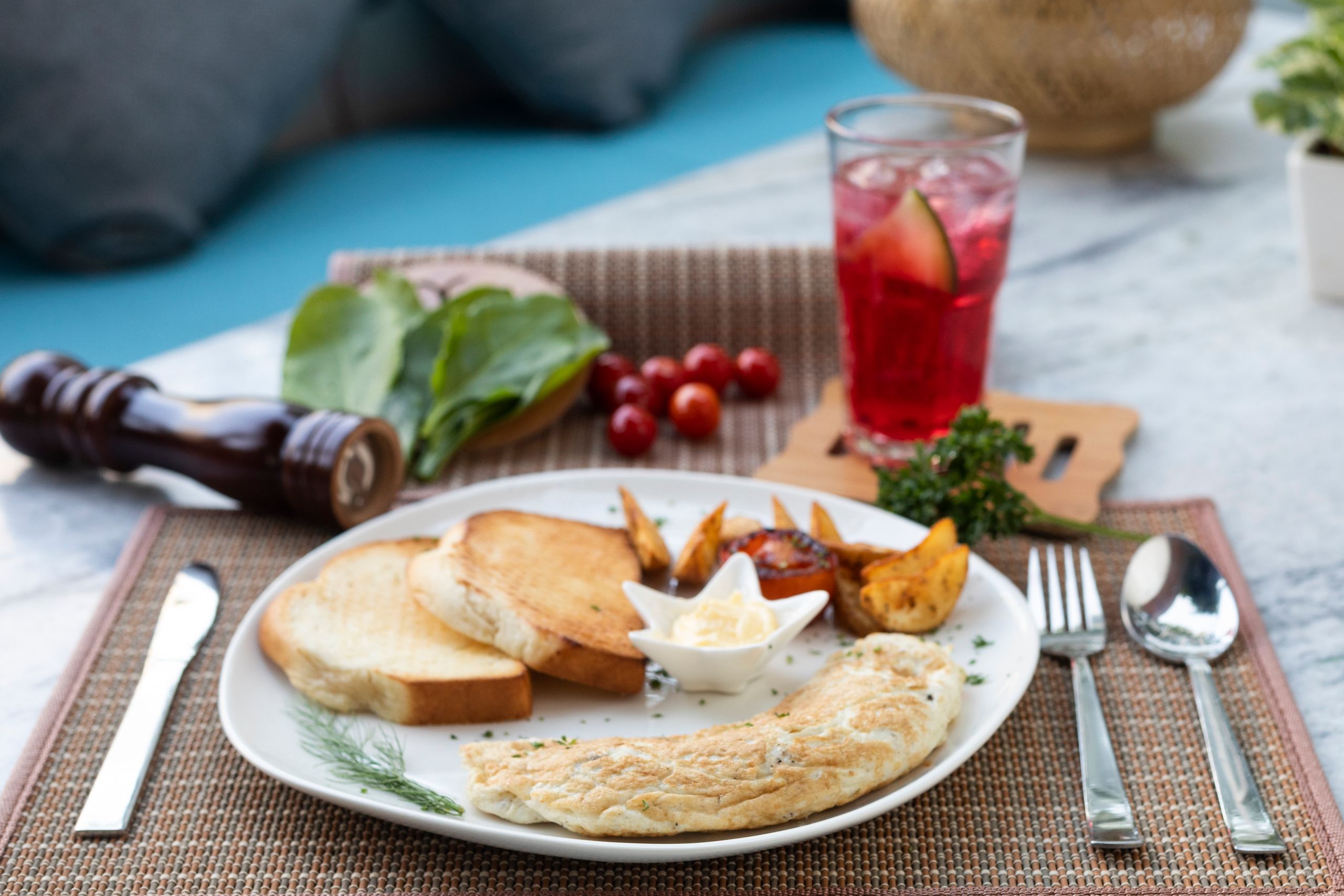 Tasty breakfast with omelette and toast on a chic table setting with a refreshing drink.