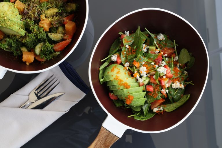 Top view of a mixed vegetable salad with avocado in a modern bowl.