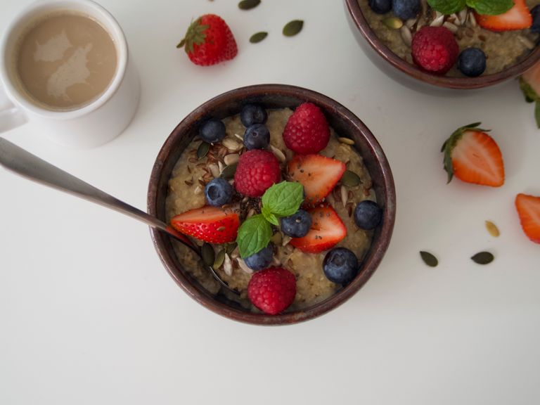 Top view of delicious oatmeal topped with fresh blueberries, strawberries, and raspberries, perfect for a healthy breakfast.