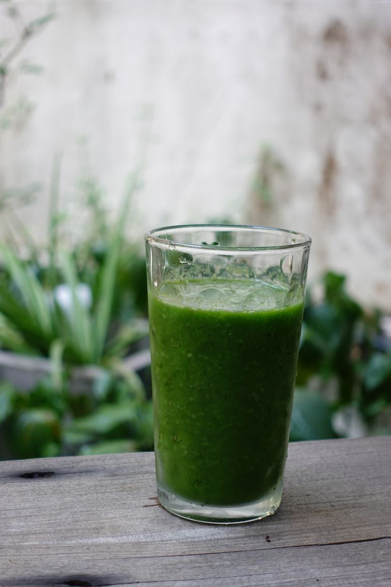 Vibrant green vegetable smoothie in a clear glass, ideal for a healthy, refreshing drink.